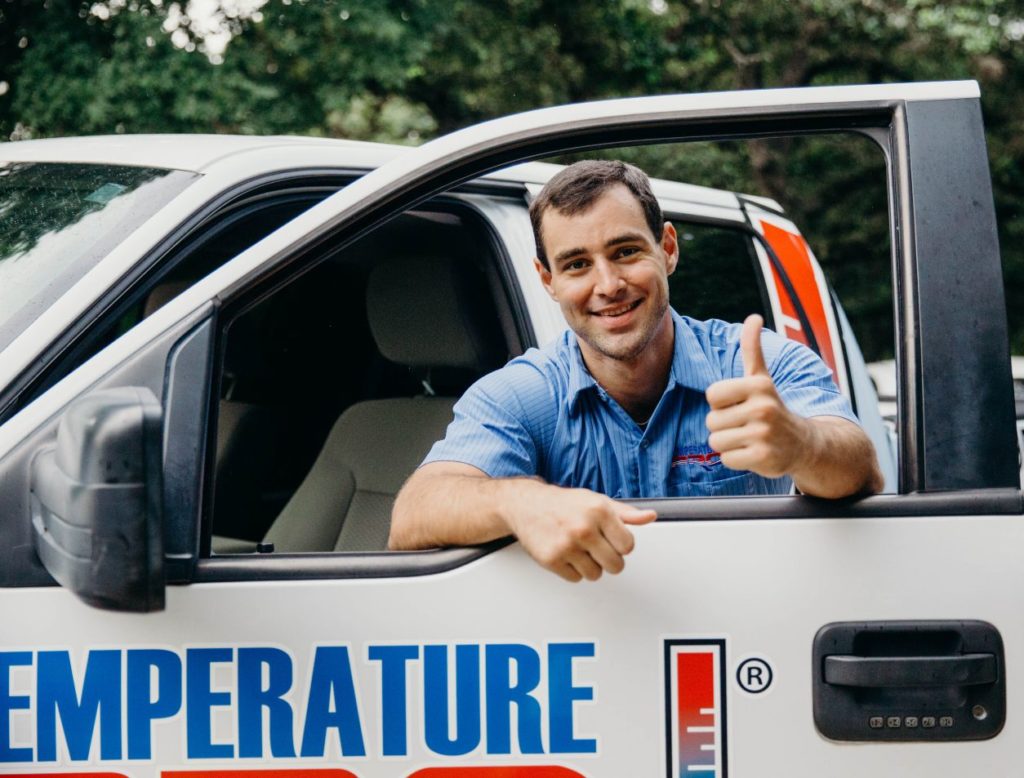 A TemperaturePro tech giving a thumbs up with their arms through the open window of a TemperaturePro truck.