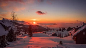 A snowy mountain landscape at sunset
