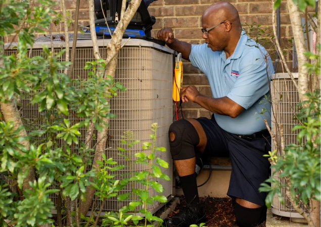 Midwest City HVAC technician installing a new AC condenser outside of a customer's home.