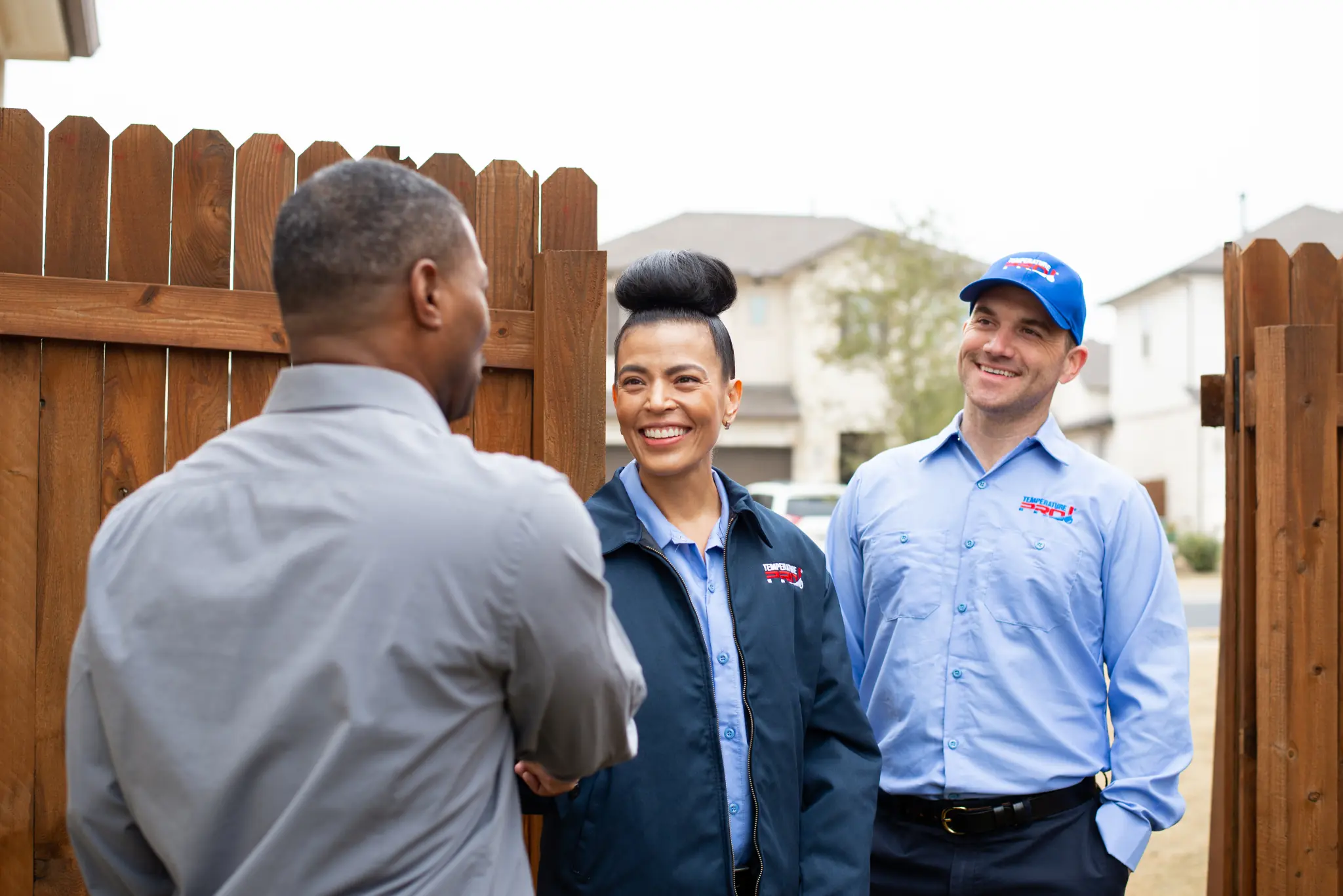 Two Buxmont heating technicians shaking hands with a customer as they arrive for heating services.