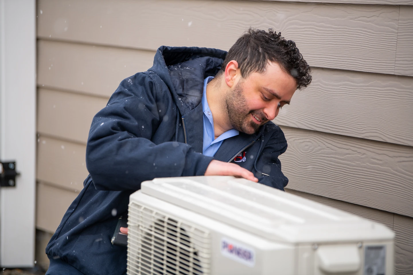 Inland Northwest heating technician inspecting an outside HVAC unit.