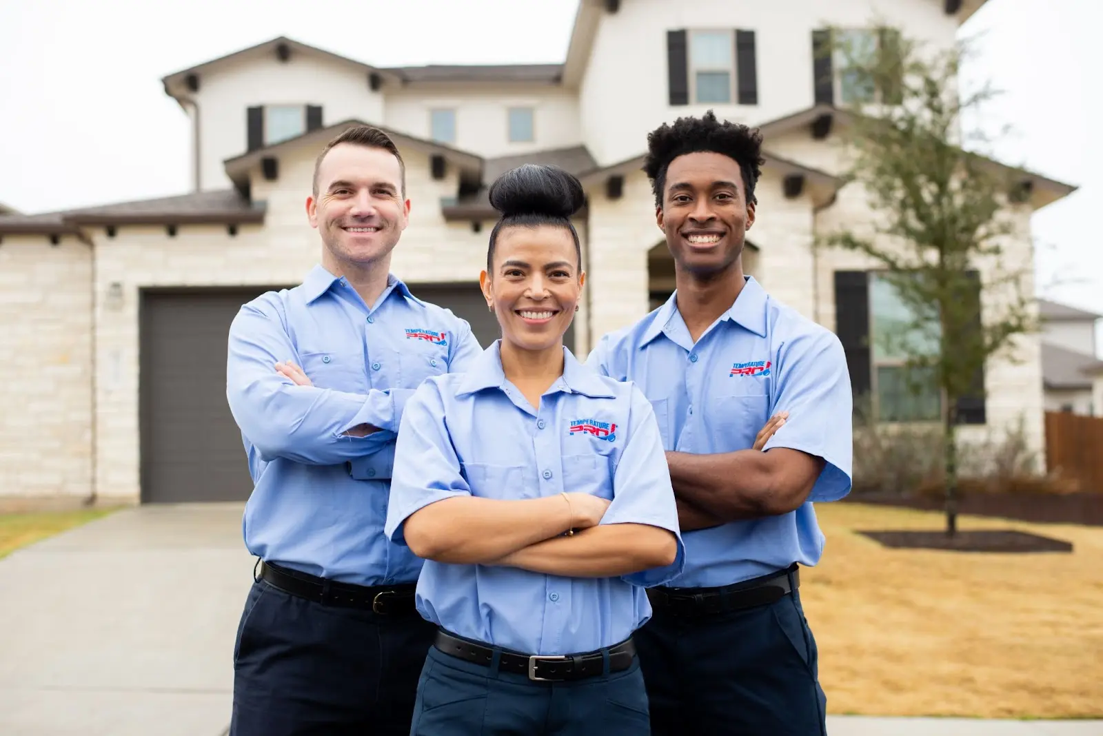Three air conditioning technicians from TemperaturePro McKinney standing outside of a customer’s home.