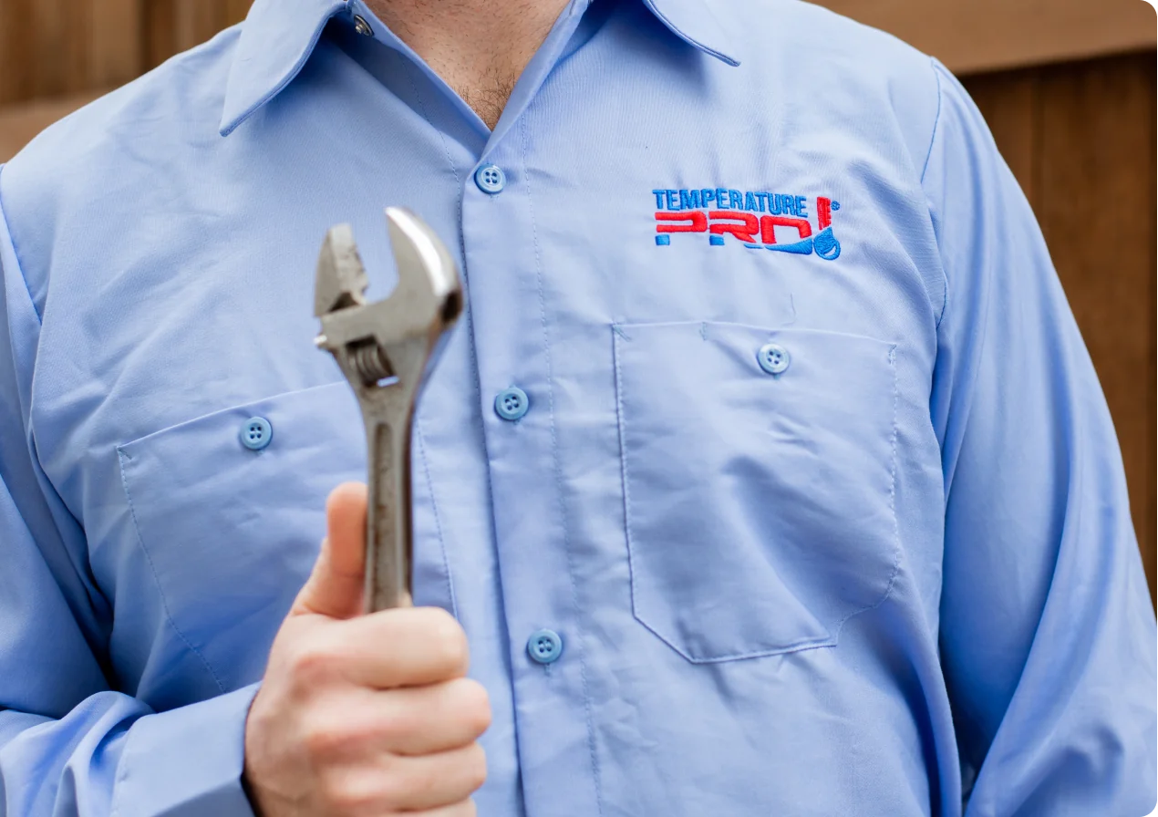 Technician with wrench in hand to perform heating services