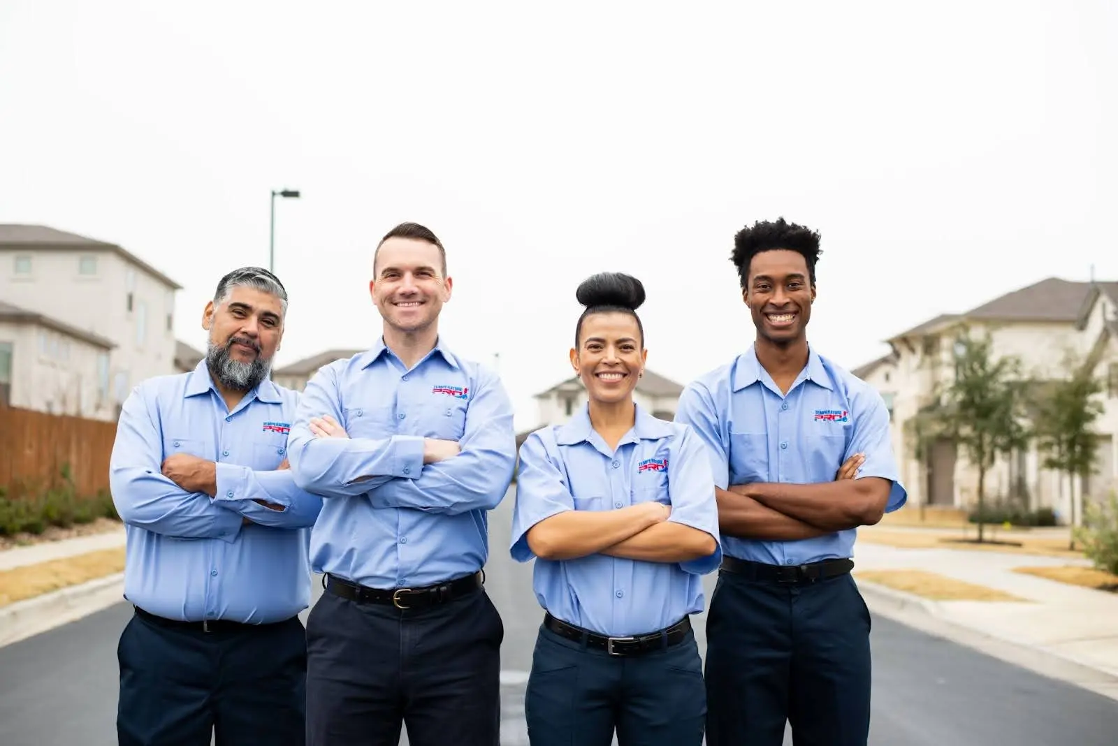 AC technicians from TemperaturePro Orlando standing street with arms crossed.