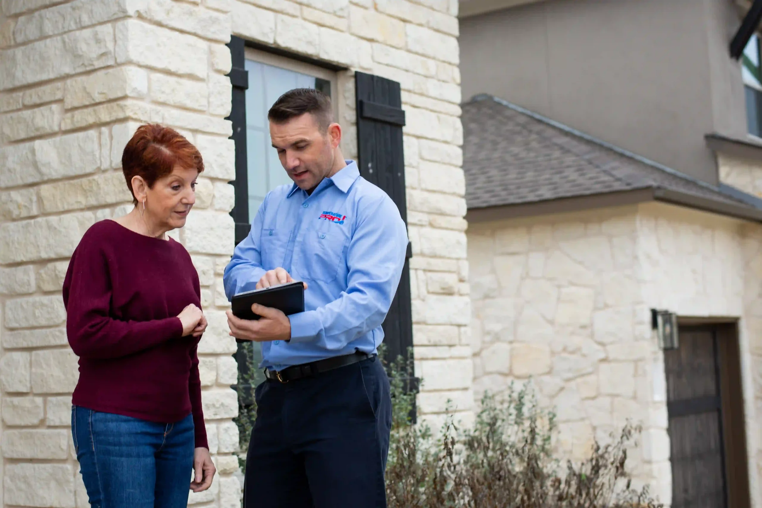 Heating installation technician showing price and project timeline to customer on an ipad.