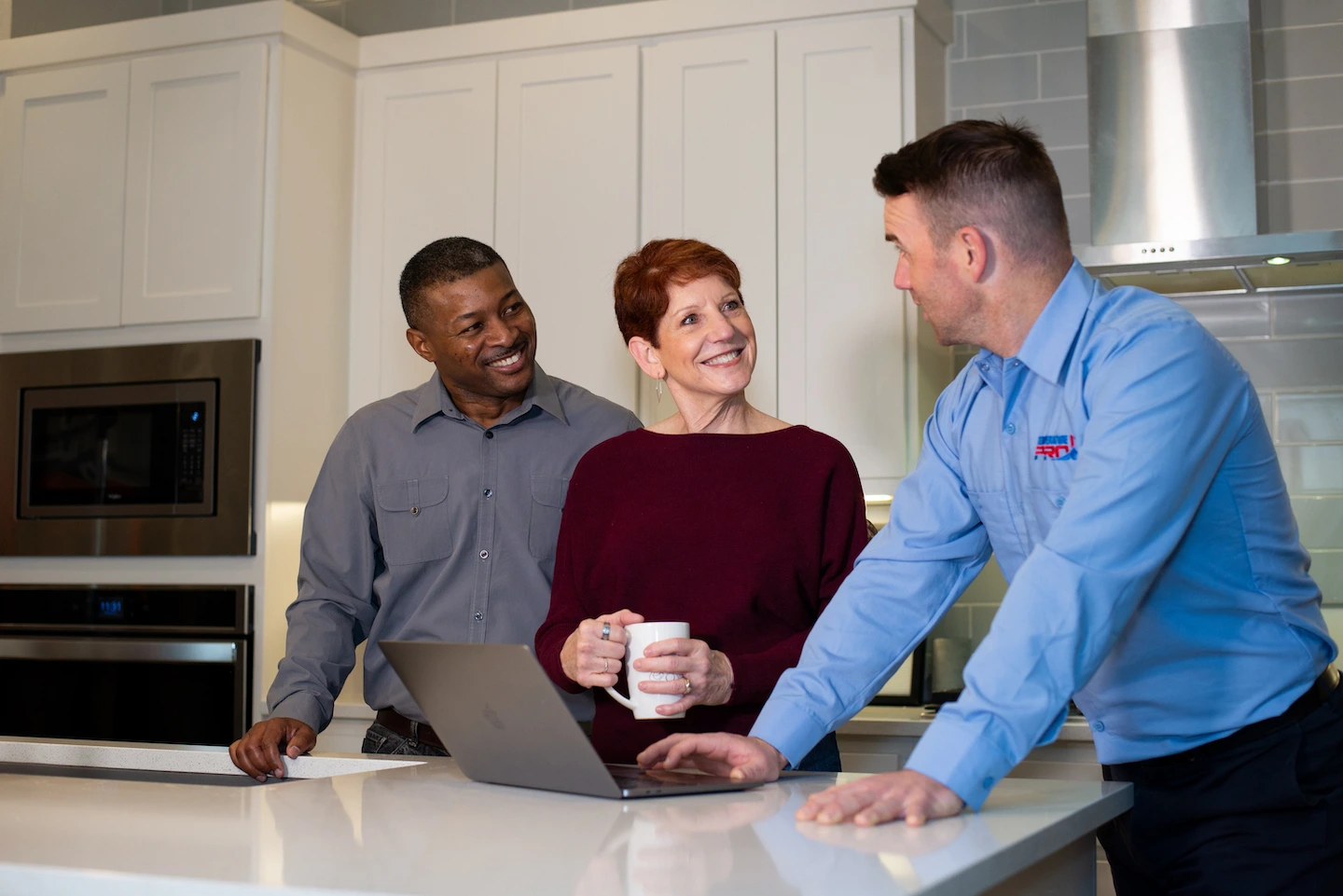 Kirkland Heating repair technician talking to homeowners at kitchen island.