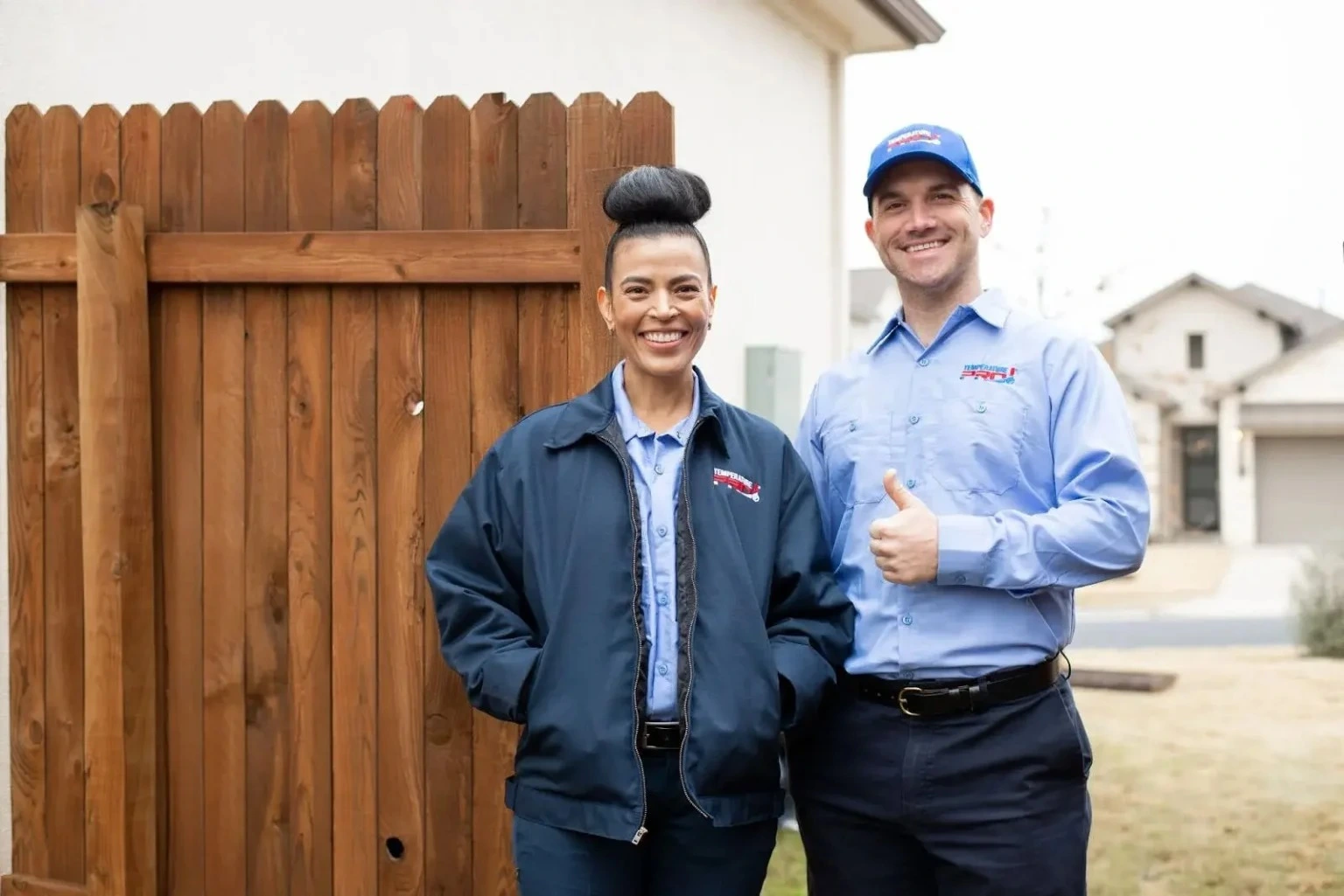 Two San Jose heating technicians from TemperaturePro standing outside of a customer's home.