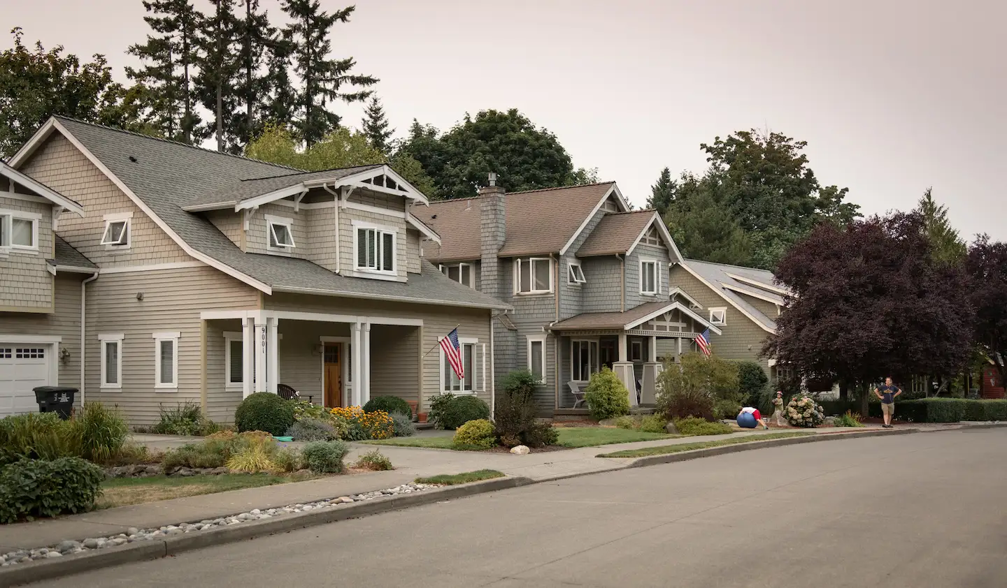 Two homes on a residential street in a West Seattle neighborhood.
