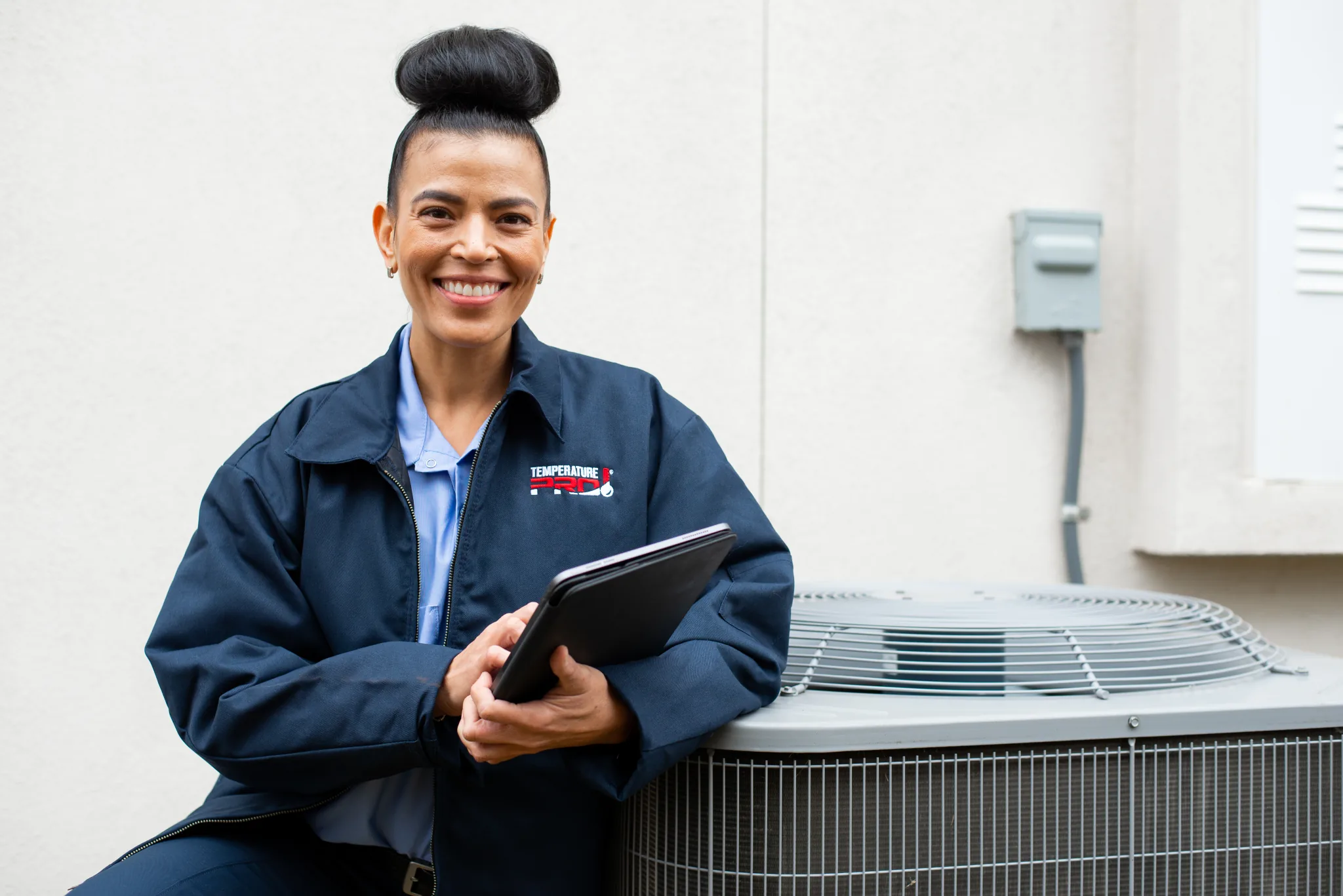 San Jose heat pump technician standing next to an HVAC unit.