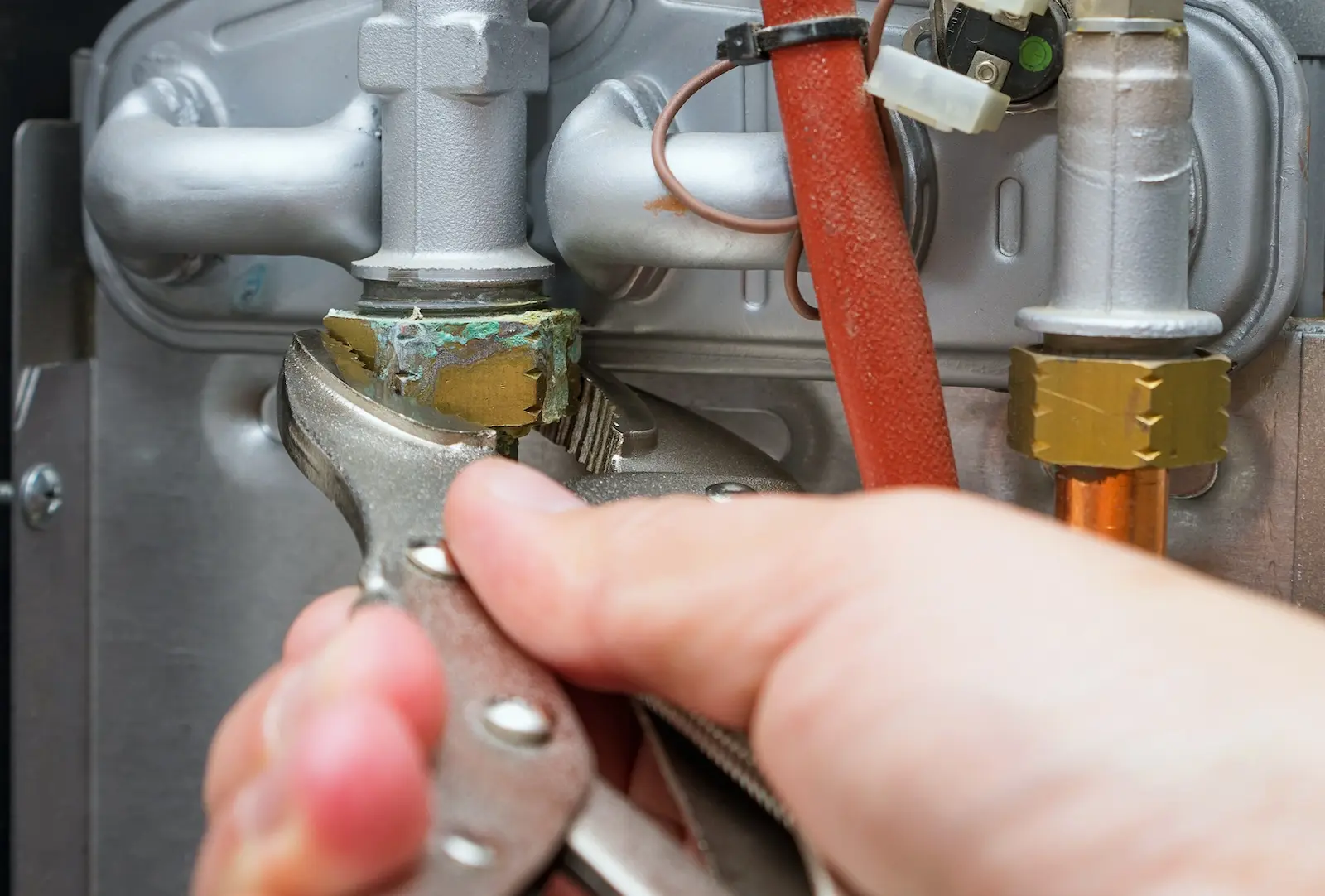 TemperaturePro Kirkland technician using a wrench to inspect broken furnace.