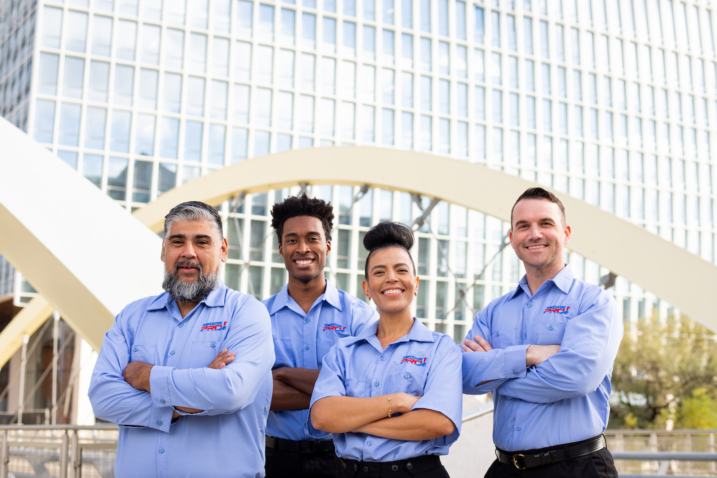 Four AC repair techs in Pasco County standing in front of a bridge.