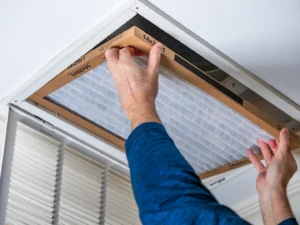 Homeowner replacing dirty air filter with clean air filter.