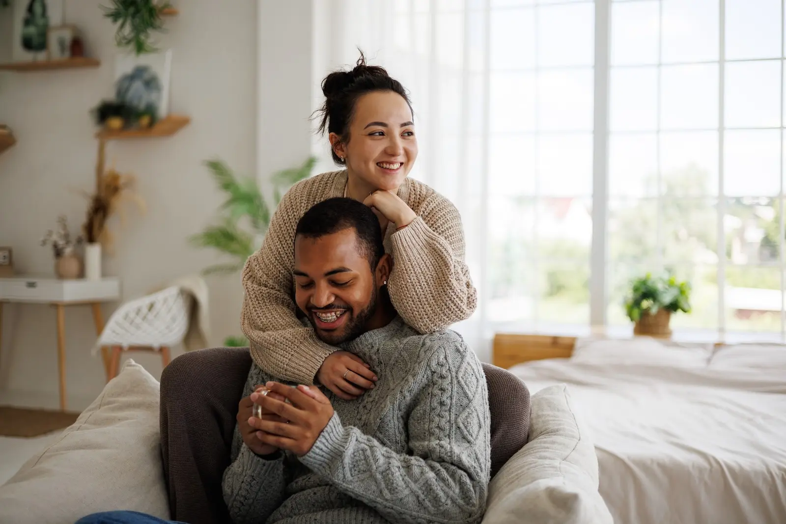 Man and woman hugging on couch staying warm inside Seattle home.