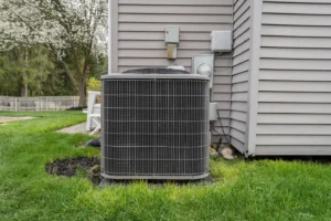 Heat pump outdoor condenser unit in backyard of home in San Jose.