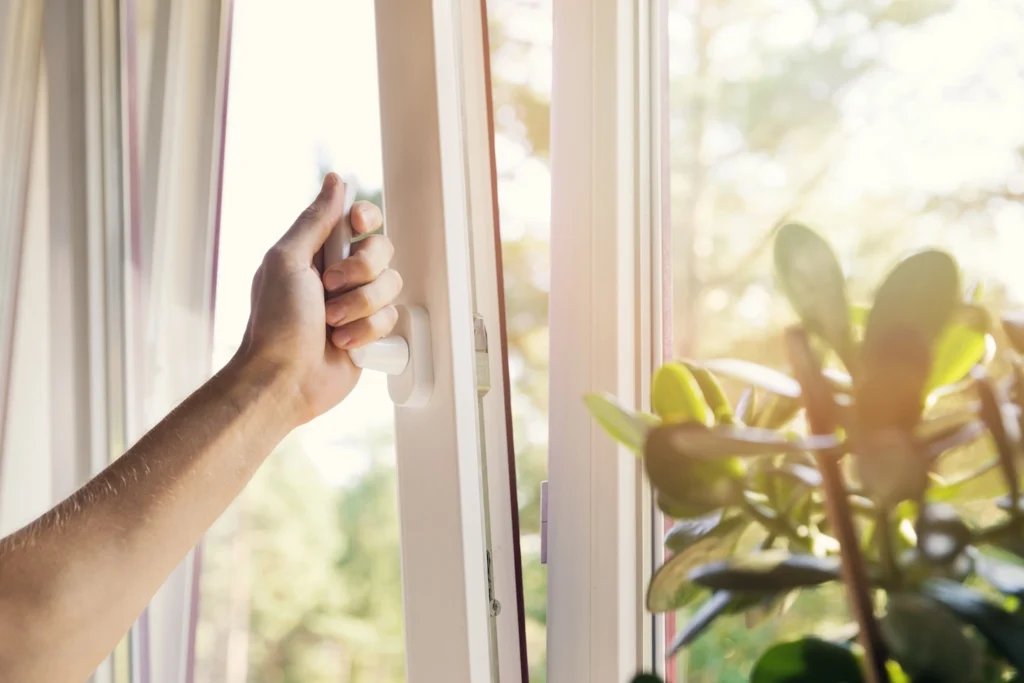 Homeowner in San Jose, California opening window, letting in humidity and allergens.