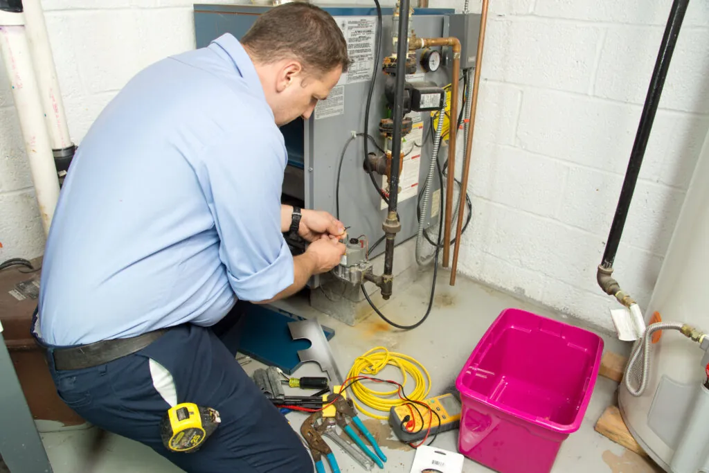 Saskatoon HVAC technician inspecting and repairing broken furnace.
