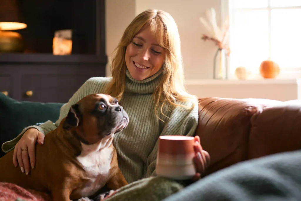 Tulsa homeowner relaxing with her dog while warm air circulates through the home from a forced air heating system