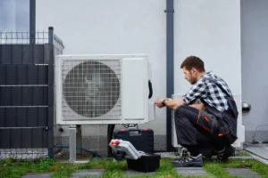 Heating technician repairing an HVAC system outside a clients home.