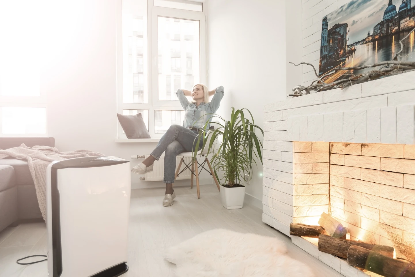 Woman at home enjoying fresh air thanks to her air purifying filter.