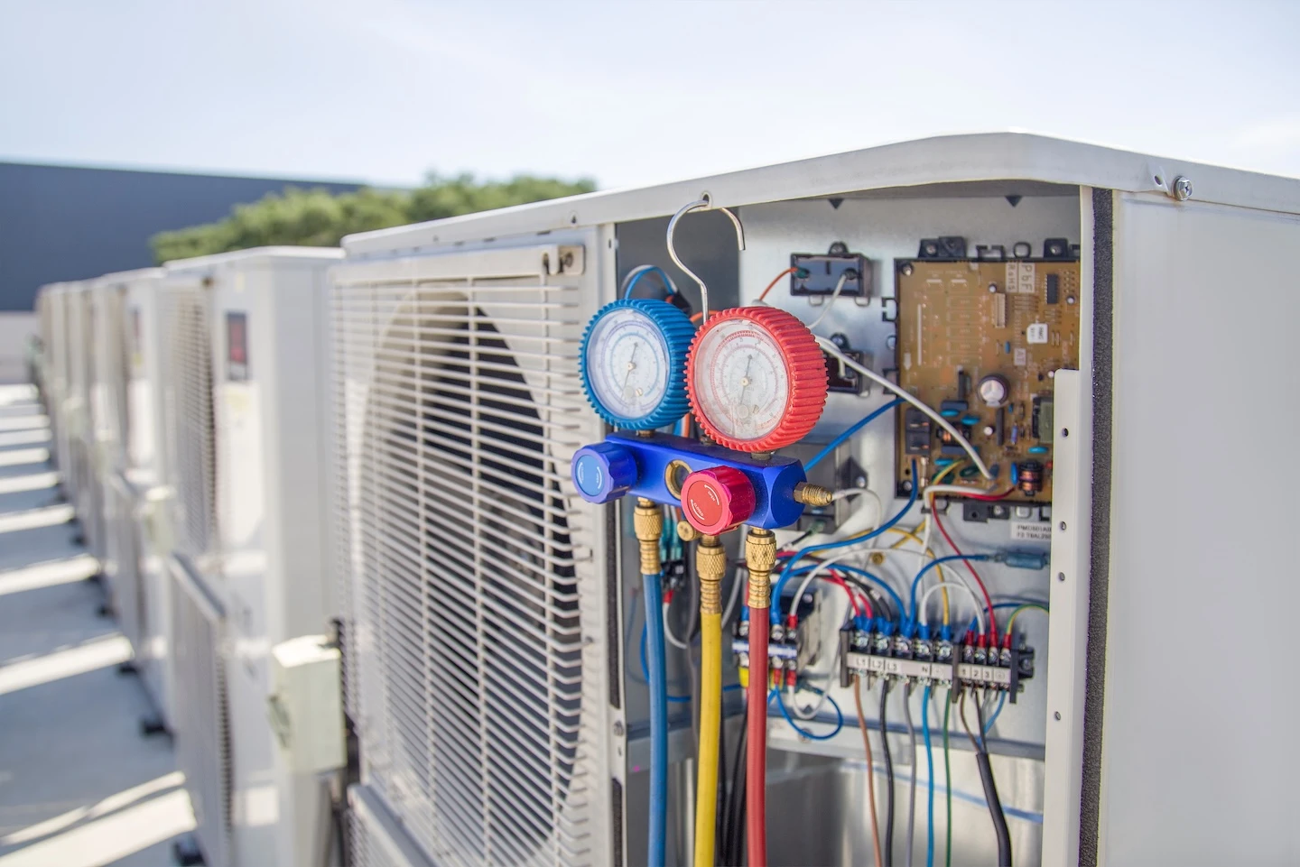 Checking refrigerant levels on a rooftop AC unit.