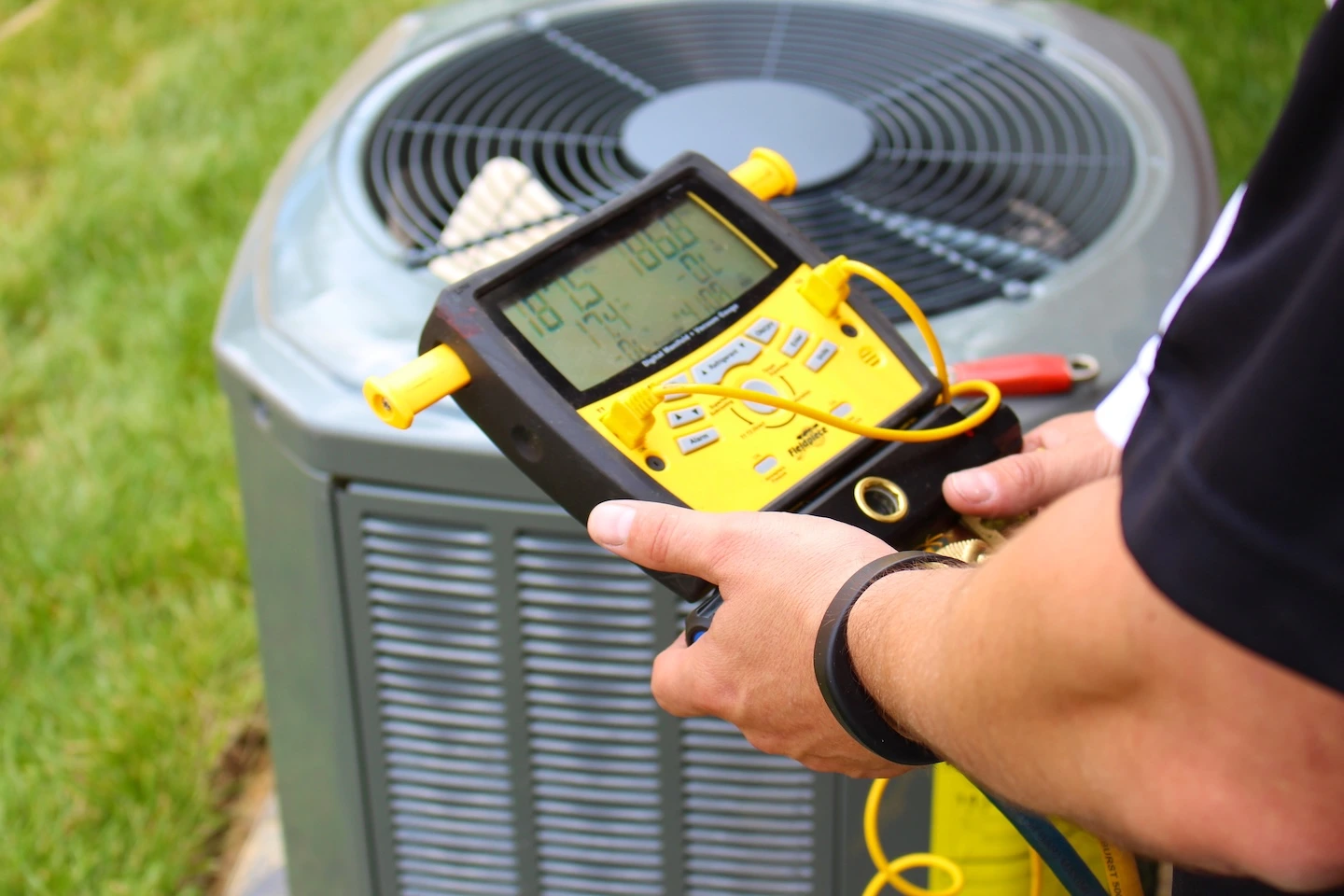 Technician checking the voltage on an outdoor AC unit.