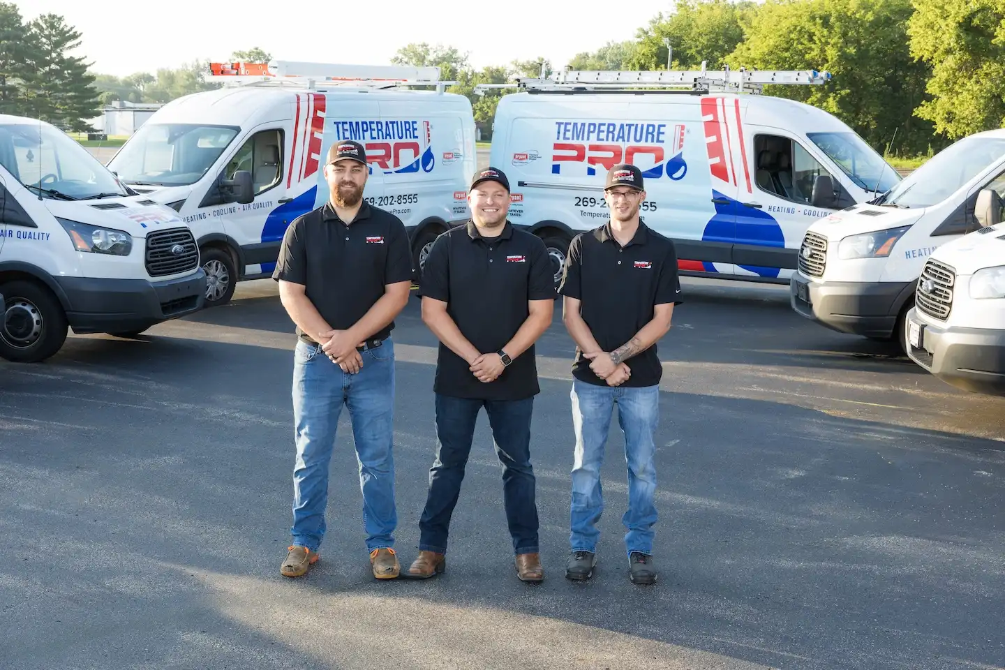 TemperaturePro technicians standing in front of branded service vans